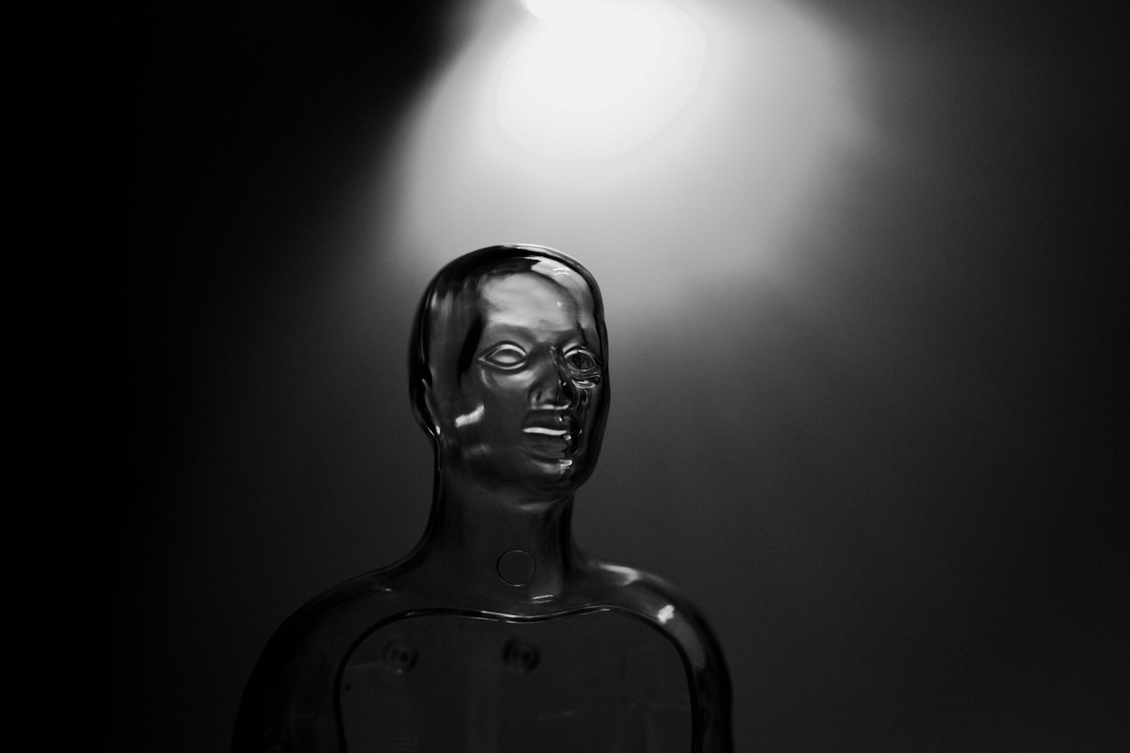 A futuristic transparent mannequin illuminated by dramatic, monochrome lighting.